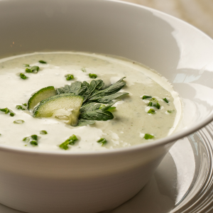 Kalte Gurkensuppe mit frischen Kräutern in weißer Schale (Serviervorschlag)