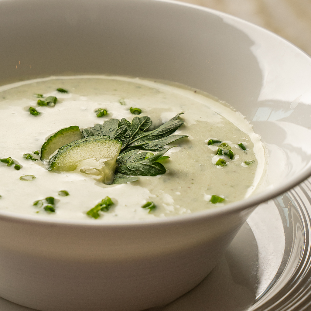 Kalte Gurkensuppe mit frischen Kräutern in weißer Schale (Serviervorschlag)